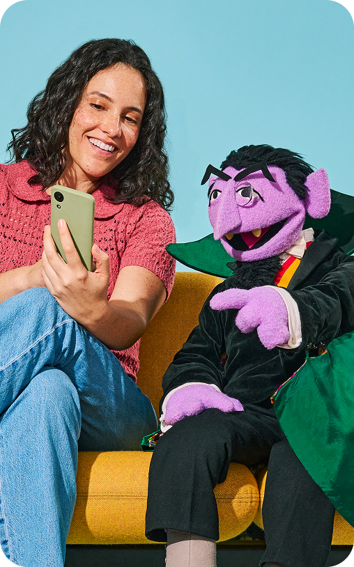 Woman sitting with the Take9 character and looking at a phone
