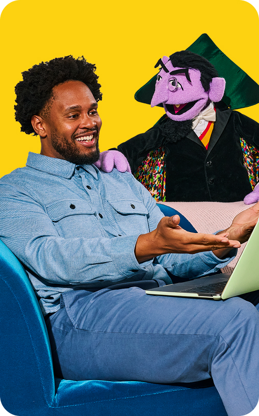 Man sitting with the Take9 character and a laptop